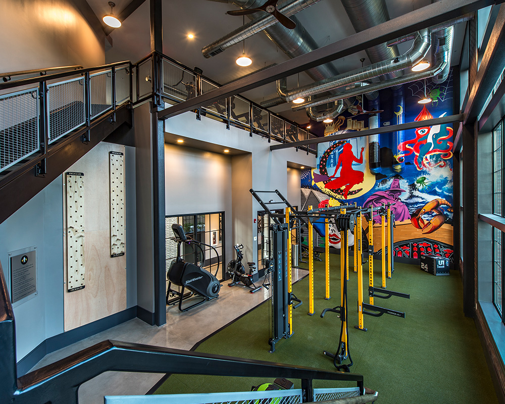 Gym with new equipment and mural at Halstead Salem Station apartment complex