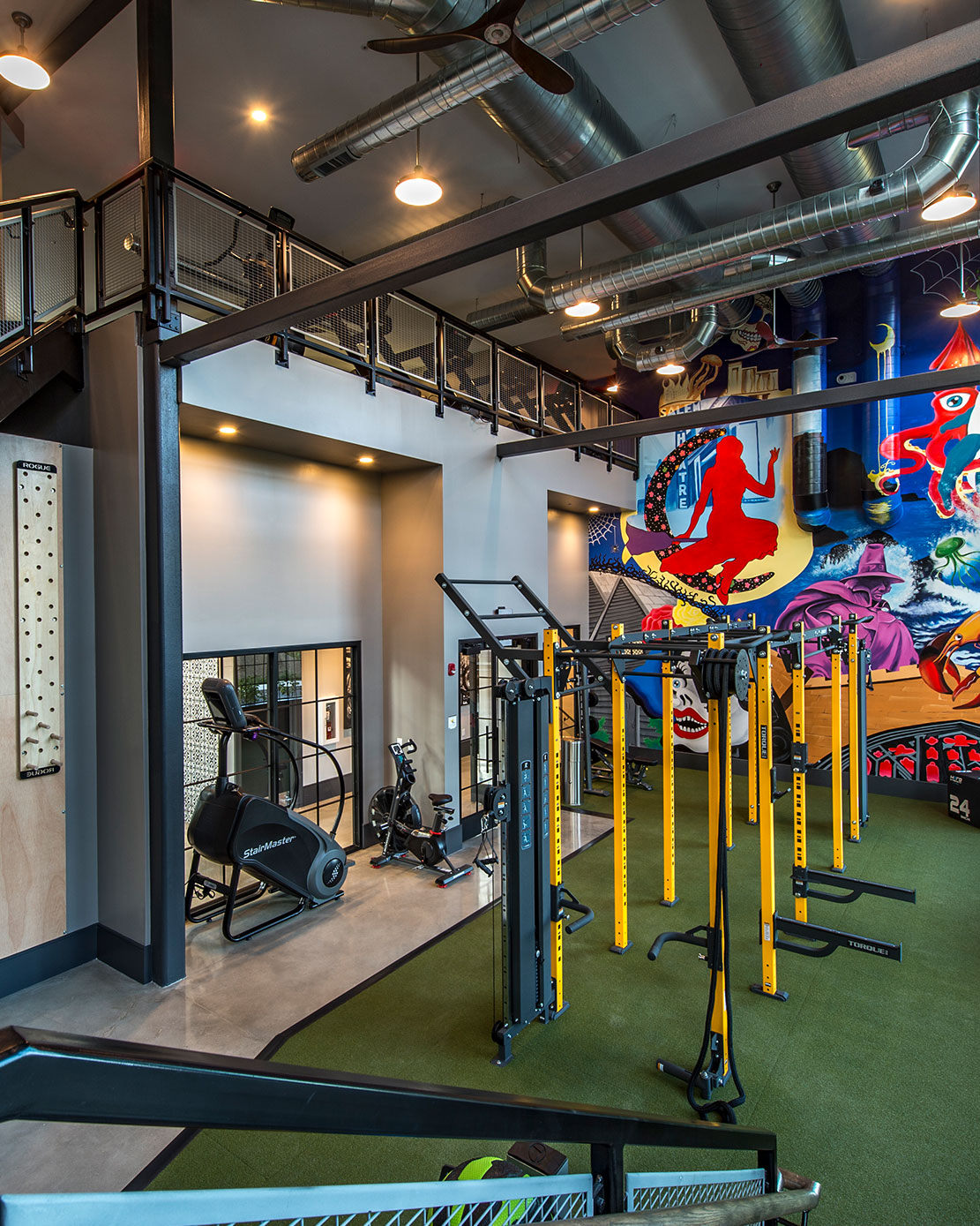 Gym with new equipment and mural at Halstead Salem Station apartment complex