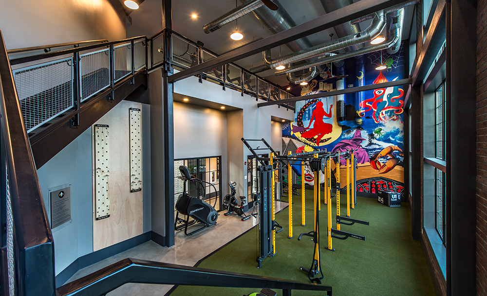 Gym with new equipment and mural at Halstead Salem Station apartment complex