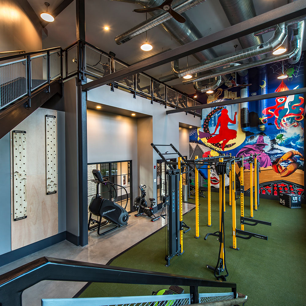 Gym with new equipment and mural at Halstead Salem Station apartment complex