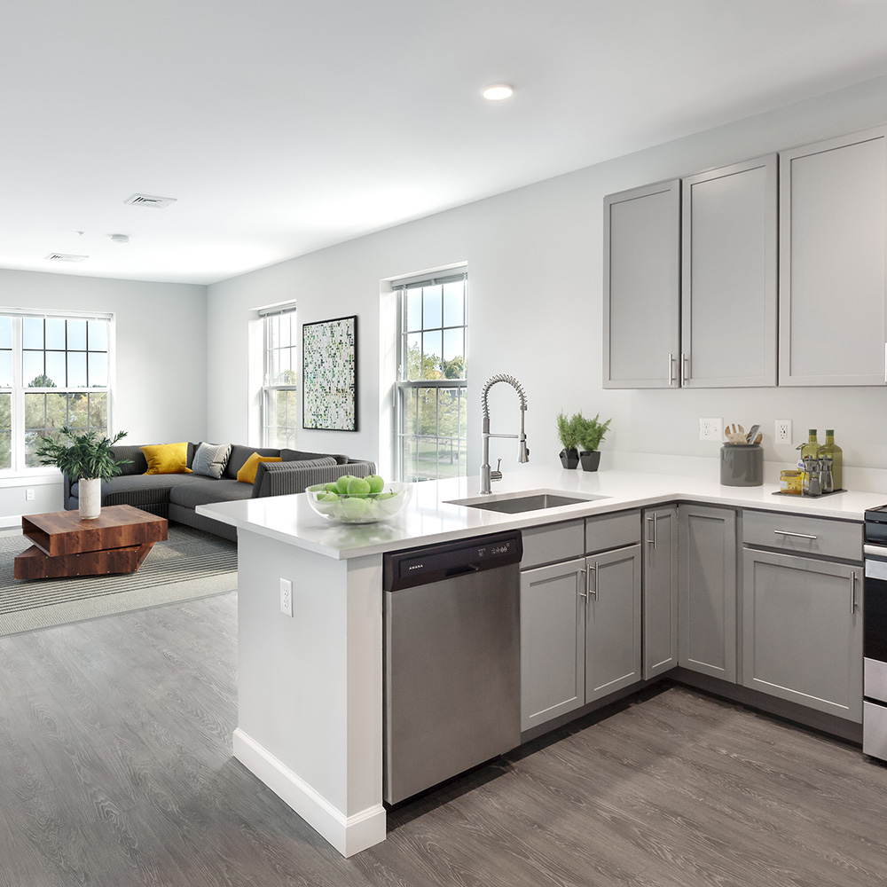 Open concept kitchen looking into spacious living room at a Halstead Salem Station apartment