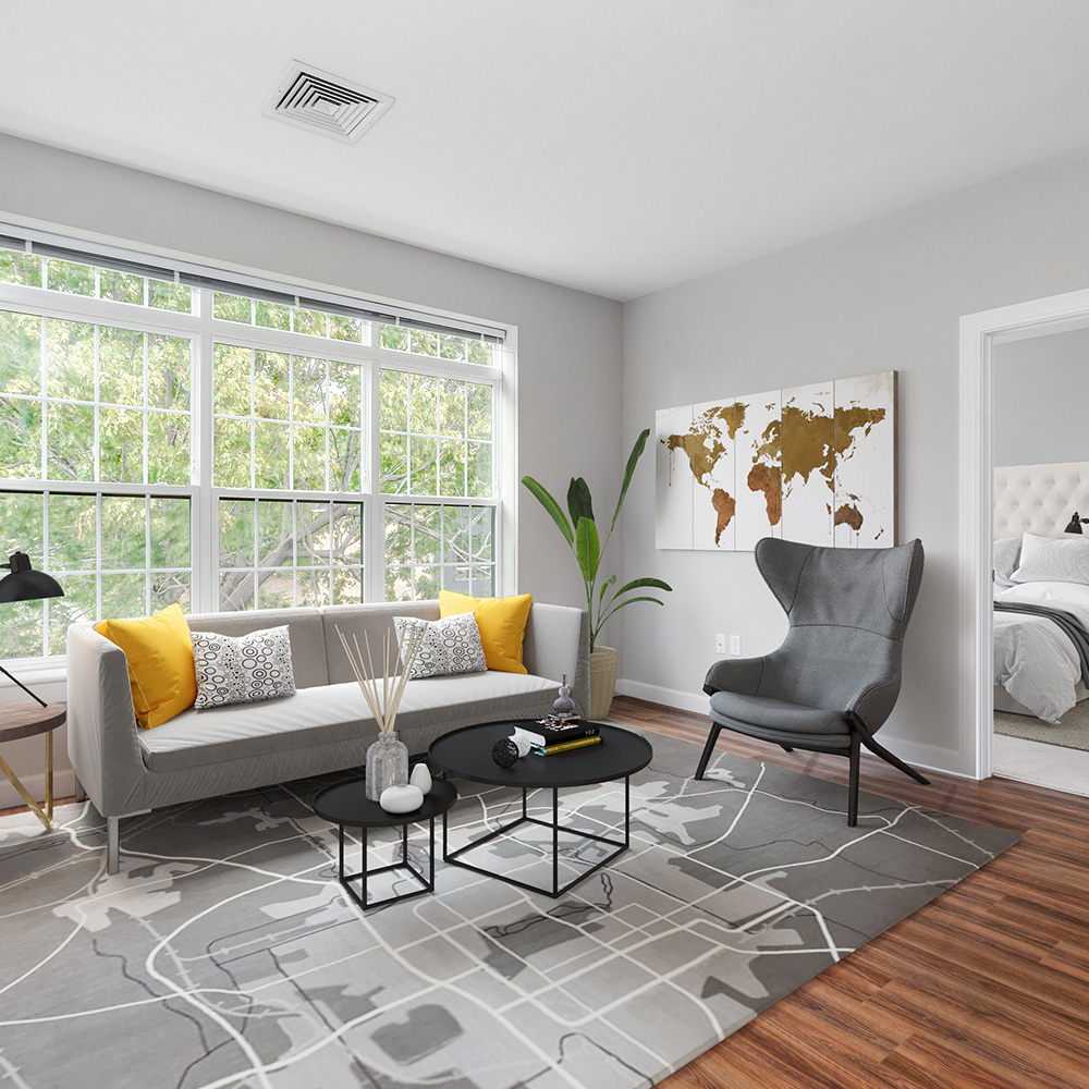 Living room with large windows in one-bedroom floor plan apartment unit