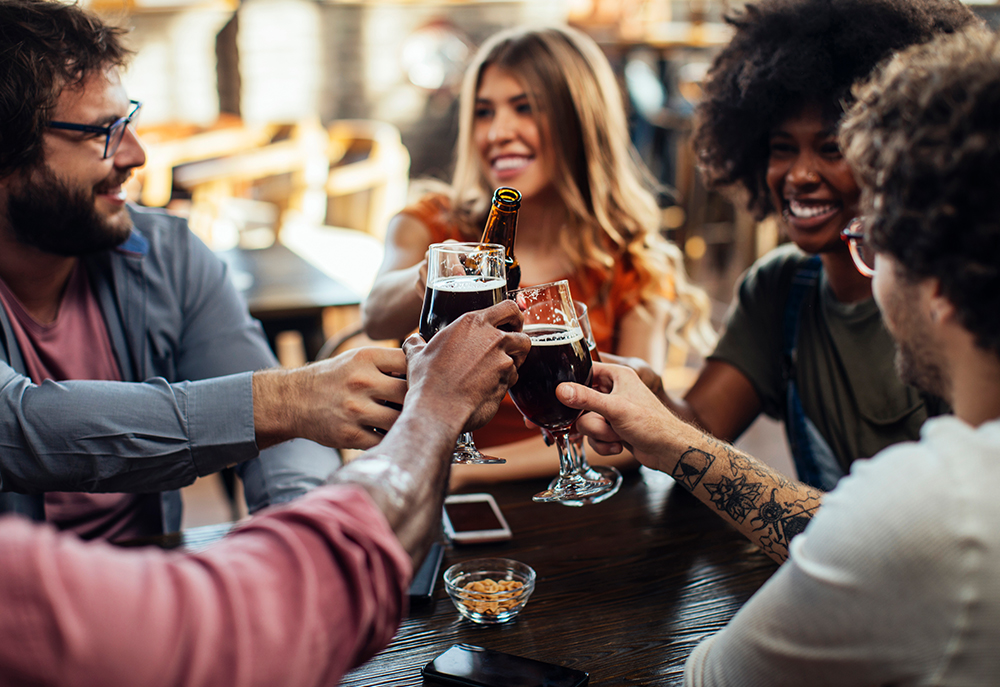 A group of five friends toast at a local Salem restaurant
